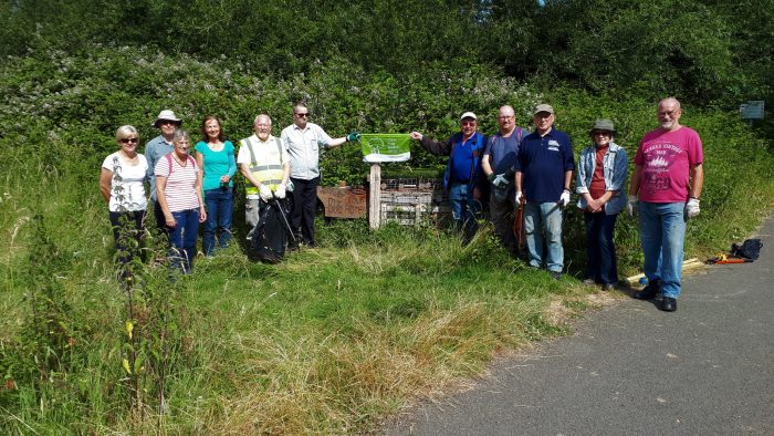 Members of Wapley Bushes Conservation Group showing off their eighth Green Flag Community Award at one of the Bug Hotels during their July work morning at the Local Nature Reserve.