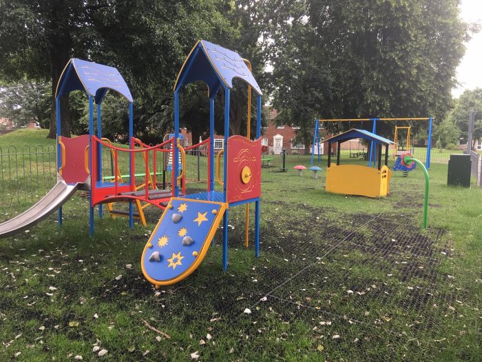 Photo of play equipment at Woodchester toddler play area including a multiplay and swings
